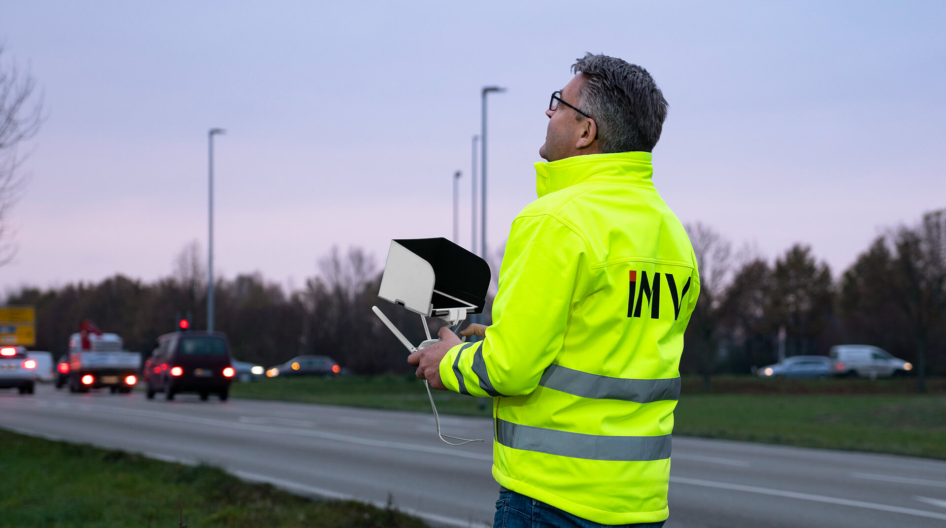 Mann mit Warnweste steuert Drohne